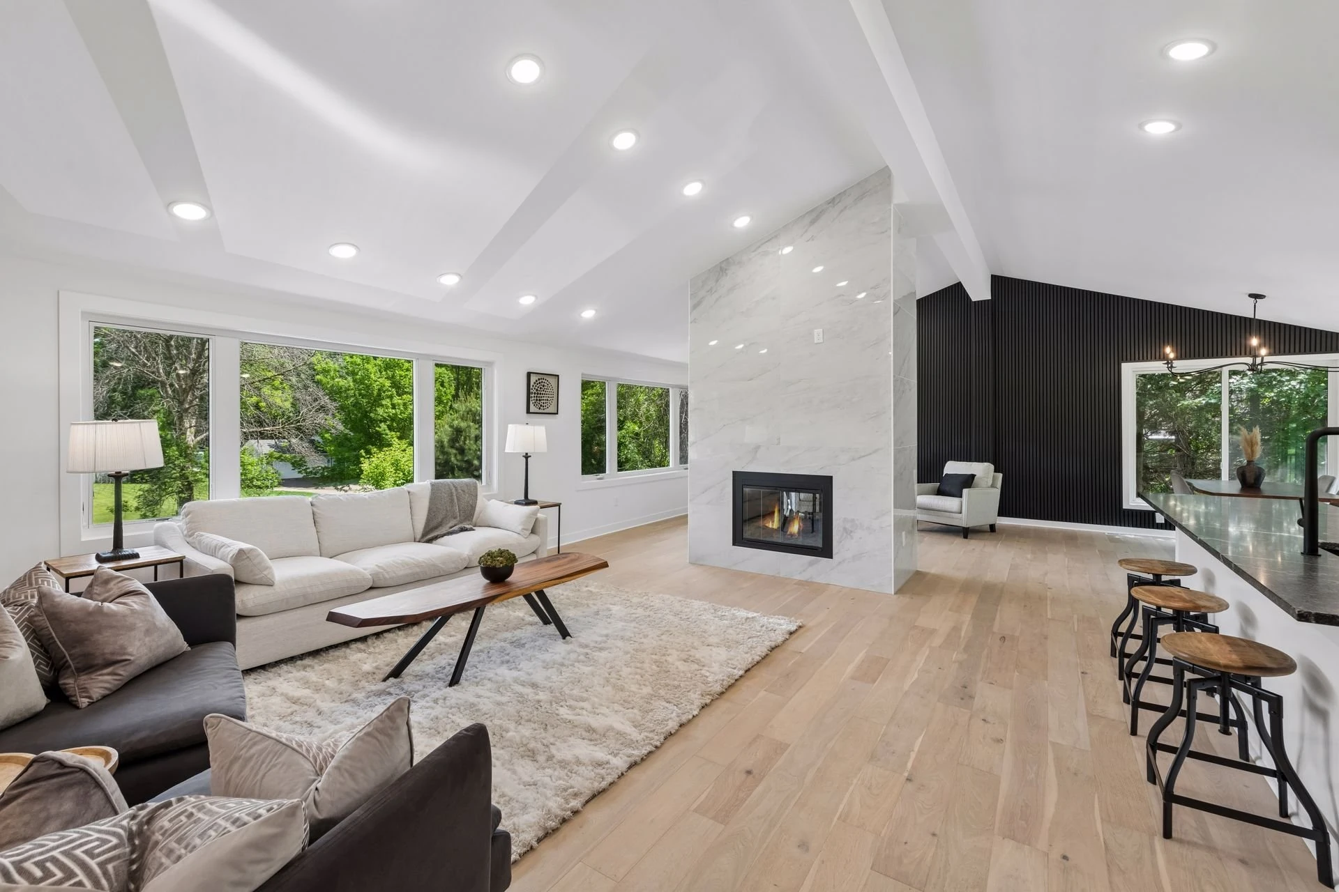 Open living room with a fireplace flowing into the remodeled kitchen