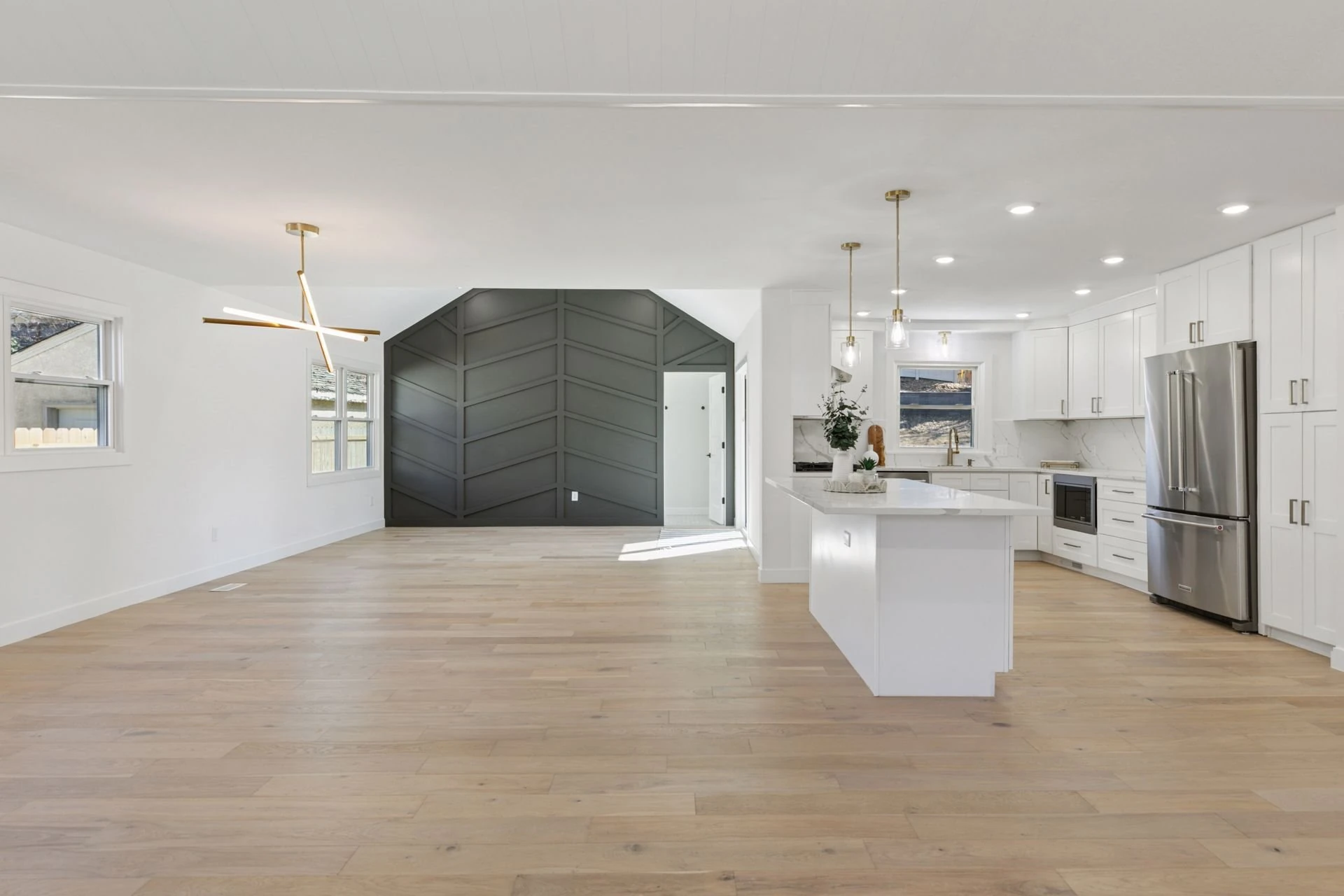 Wide view of an open-plan living area and kitchen after a full renovation